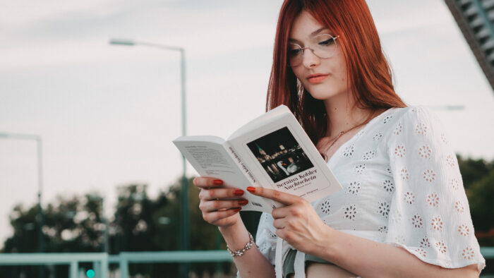 Nachtschein Seraina Kobler Frau mit roten Haaren hält Buch in der Hand