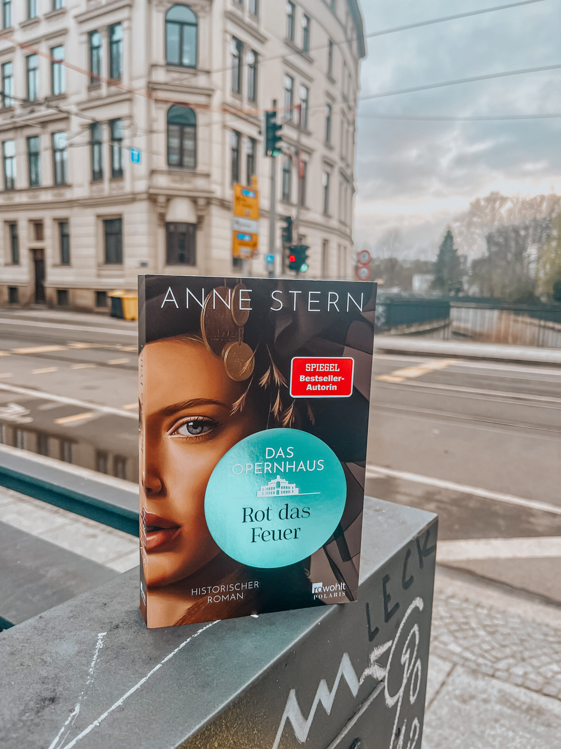 Rot das Feuer von Anne Stern historischer Roman Buch vor historischen Gebäude in Leipzig
